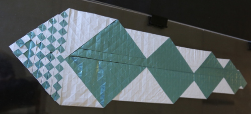 échiquier 11x11
Un carré de 60x60, une couleur par face, donne un échiquier 11x11. La solution est très probablement optimale. La moitié du modèle est dépliée pour sentir la complexité du modèle. Très probablement le plus grand échiquier effectivement plié (un record ?). Image : INSA de Lyon. Plus d'informations ? Consultez http://arxiv.org/abs/1510.07499
Mots-clés: changement_couleur complexité