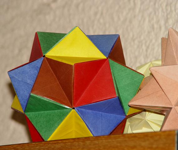 Je ne sais plus le nom géométrique de cette forme
alors celui_ci pour l'assembler correctement sans se planter dans le rythme des couleurs, bonsoir !
Pour la présentation, je l'ai collé et vernissé. je ne sais pas si ça se fait...
à côté vous apercevez le kusudama du livre de Rick Beech mentionné ailleurs. Avec son imbrication par l'intérieur, il était coton aussi celui-là. et aussi une étoile que je montrerai mieux quand j'aurai la photo  ;-))
Pour tous ces assemblages, un saladier est mon ami le plus cher.
