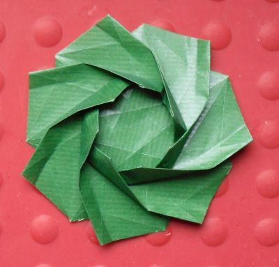 Heptagonal Flower Twist 
1er essai. Plié dans du Kraft bicolore à l'odeur si particulière. 21*21 au départ
Support photo, dessous de plat en silicone rouge (Pour le contraste)
