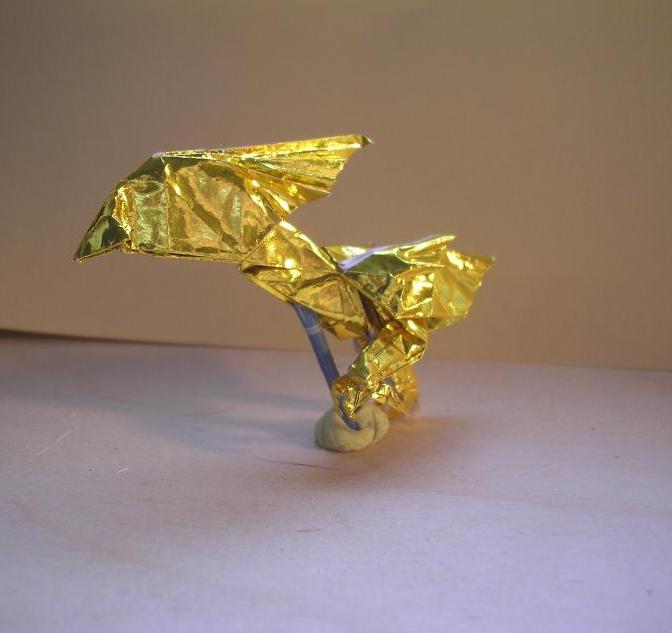 le chocobo or, effets de lumière coté gauche (Kamiya Satoshi)
j'ai voulu essayer de le faire courir, j'ai plus ou moins réussi au final, même s'il ne tient pas du tout debout. j'ai aussi modifié sa crête. j'aime beaucoup les jeu de lumière que le papier permet, même si ce n'est pas évident à prendre en photo.
j'ai utilisé un carré 15x15cm de papier spécial origami couleur or et blanc
