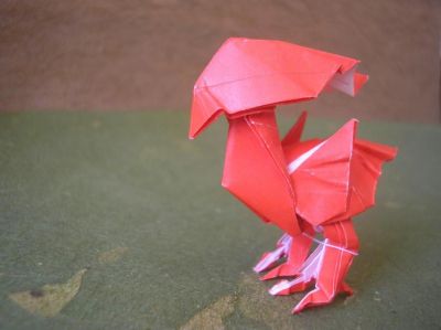 le chocobo rouge, zoom (Kamiya Satoshi)
pour celle-ci, j'ai essayé de rabattre légèrement la crête vers le bas, au contraire du chocobo bleu, je lui trouve un air plus féminin par la même occasion ^^'
j'ai utilisé un carré 15x15cm de papier spécial origami rouge et blanc
