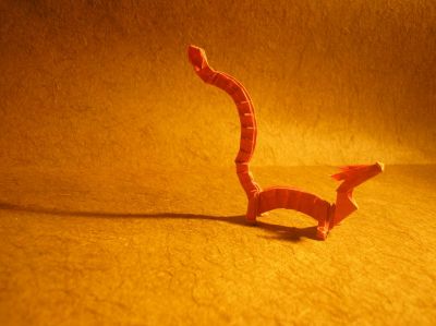 un petit dragon et son ombre (Joseph Wu, 1998)
j'ai utilisé un rectangle, rouge, de 5x29,7cm
je trouve ce dragon absolument trop mignon, il me fait penser à Mushu dans Mulan (vive les références), et je le trouve trop craquant !
le modèle n'est pas très compliqué, juste un peu long et répétitif (pour les écailles)
