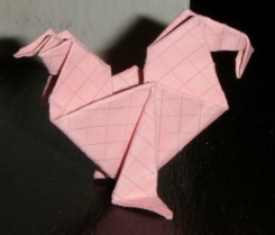 Un coq
Coq  crée par Florence temko
Plié dans un papier cartonné rouge petit carreaux carrée de 10x10cm.
