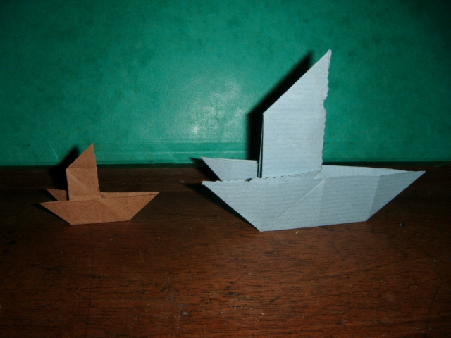  Deux bateau à voile
Bateau à voile 
Pliée dans un carré de 10x10 cm de papier kraft bleu ciel pour celui de droite et celui de gauche dans un carré de 5x5 cm de papier type emballage.
